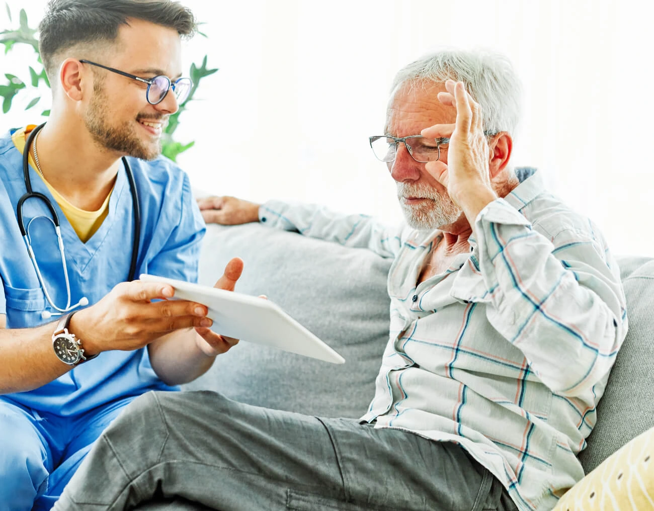 Professionelle Pflegekraft mit Tablet bei der Seniorenbetreuung - moderne digitale Pflege